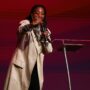 Demetria Stallings ministrando no palco do Modeladas Mais 2026, apontando para o público, ao lado da intérprete
