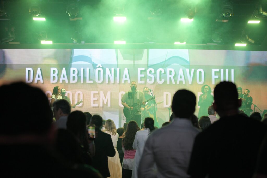 Público em adoração diante do palco iluminado de verde