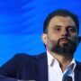 Bispo JB Carvalho, de barba e terno azul-marinho, diante do painel azul