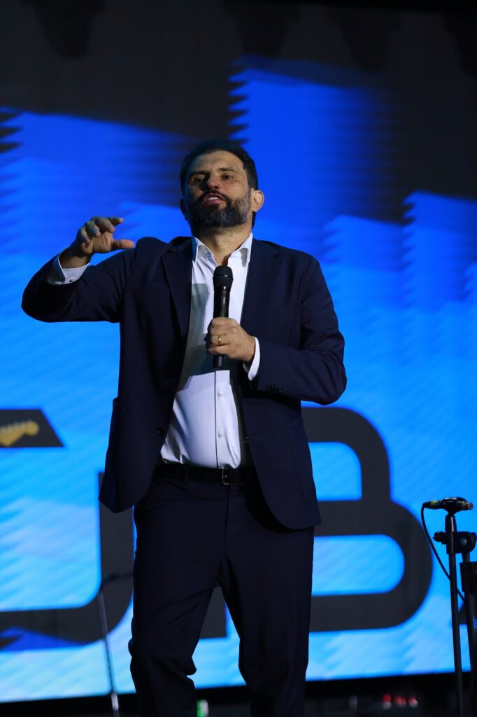 Bispo JB Carvalho fala ao microfone no palco