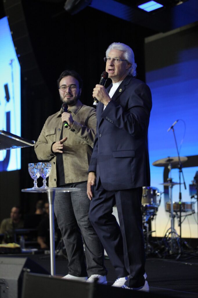 Charles Scott e o intérprete no palco, ao lado do púlpito de acrílico