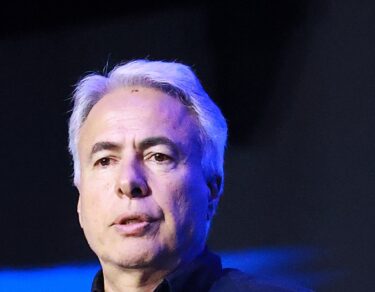 Marcos Borges, o Coty, de cabelos brancos e camisa azul marinho, fala ao público